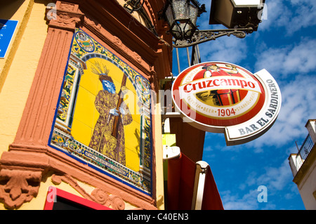 Religious mural and beer advertising sign on a cafe bar in the city Stock Photo