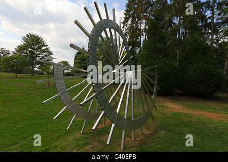 Contemporary Sculpture Garden at Burghley House. Modern sculpture of a metal wheel in the landscape garden. Stock Photo