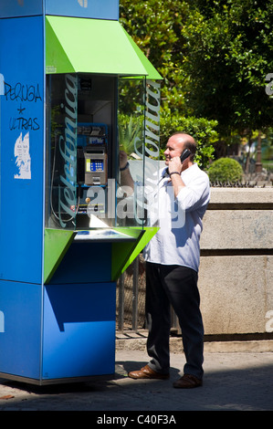 Man using public telephone in the city Telefonica SA Stock Photo