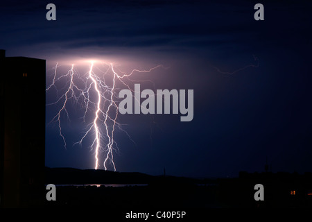 Lightning storm strikes over city and sea Stock Photo