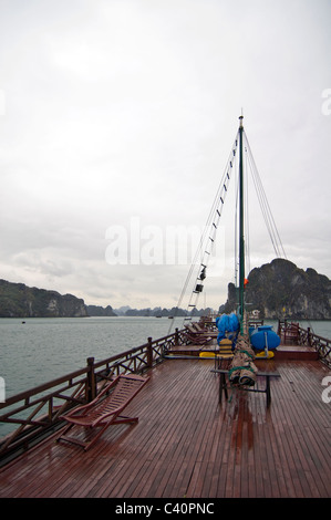 Vertical view of the limestone karsts (rocks) in Halong Bay from the top deck of a traditional wooden junk used for tour guides. Stock Photo