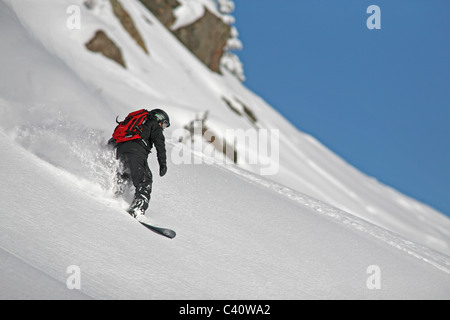 Snowboarder enjoys fresh, deep powder off piste at Brighton Ski Resort in Salt Lake City, Utah. Stock Photo