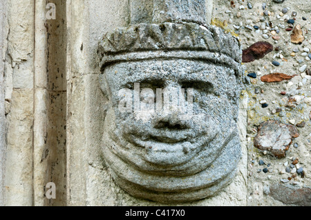 Stone carving of a humorous head on the south porch of St Andrew's church, Shalford in Essex. Stock Photo