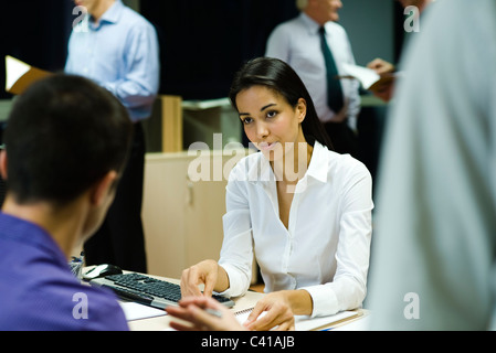 Colleagues discussing work in office at night Stock Photo