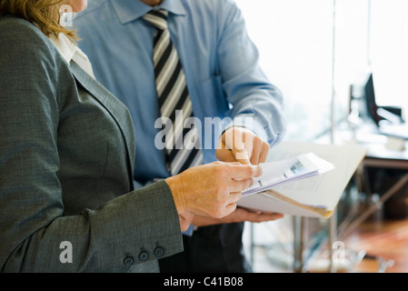 Colleagues discussing work in office, mid section Stock Photo