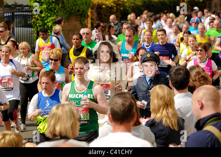 Runners take part in the Virgin 2011 London Marathon  with runners wearing mask of Prince William and Catherine in wedding dress Stock Photo