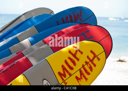 Ready for the Surf: Rental surfboards stacked on Waikiki beach. A stand of red, blue and yellow surfboards await renters