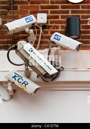 Group of four CCTV security cameras mounted on a wall in the UK Stock Photo
