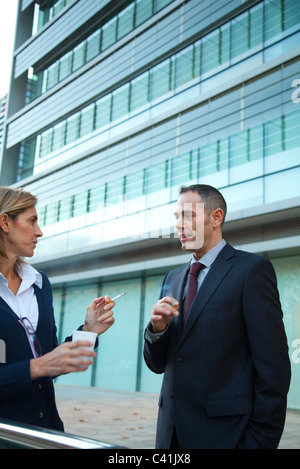 Colleagues taking smoke break outdoors Stock Photo