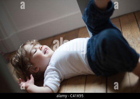 Little boy lying on floor laughing