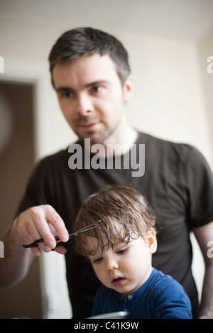 Father cutting toddler son's hair Stock Photo