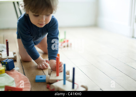 Toddler boy playing with toy train Stock Photo