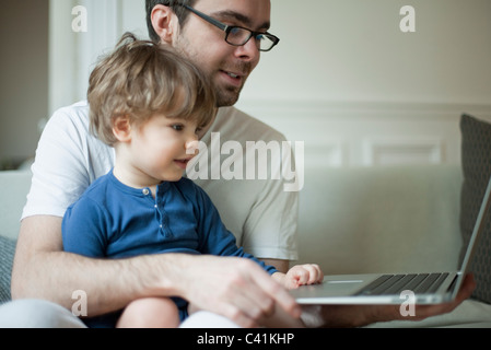 Toddler boy using laptop computer with father Stock Photo