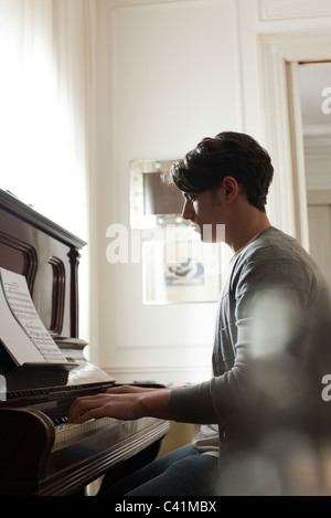Young man playing piano Stock Photo