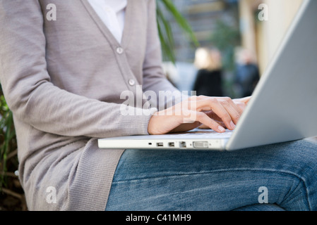 Woman using laptop computer outdoors Stock Photo