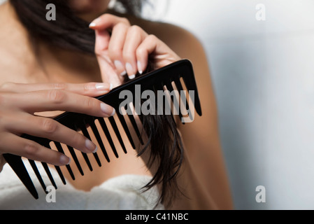 Woman combing her hair, cropped Stock Photo