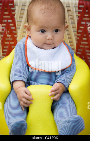 Baby sitting on booster seat, portrait Stock Photo