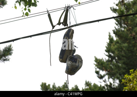 Pair of trainers hanging from overhead wires Stock Photo