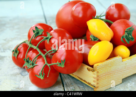 several varieties of tomatoes in a box on the table Stock Photo