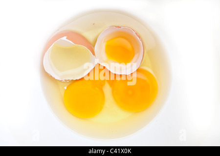 Two raw eggs with egg shell in a white bowl Stock Photo
