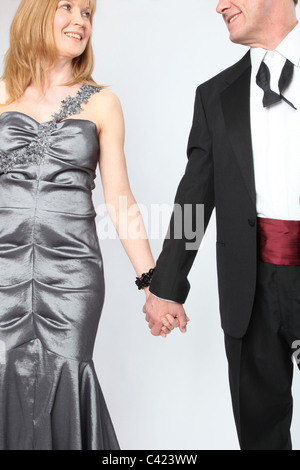 Couple wearing evening wear hold hands Stock Photo