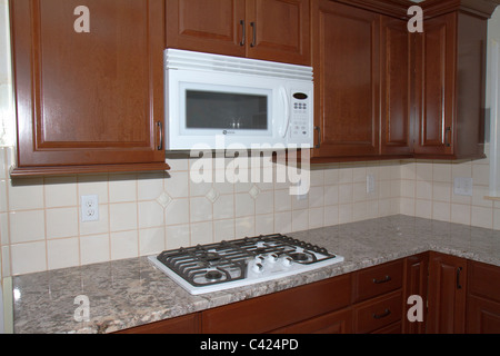 New cherry cabinets, granite counter tops, and ceramic tile floor highlight kitchen remodeling job in Massachusetts home. Stock Photo