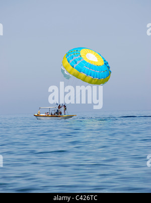 Paraglider airborne being towed by a boat at sea Stock Photo