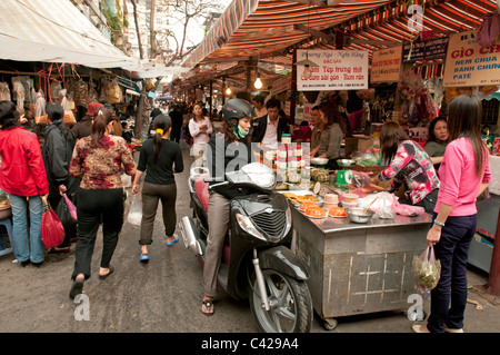 A Vietnamese lady shopping on her moped in one of Hanoi's many daily food markets in Vietnam Stock Photo