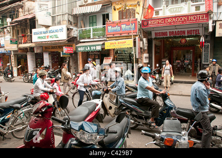 A street in the old quarter of Hanoi Vietnam teeming with mopeds and bicycles Stock Photo