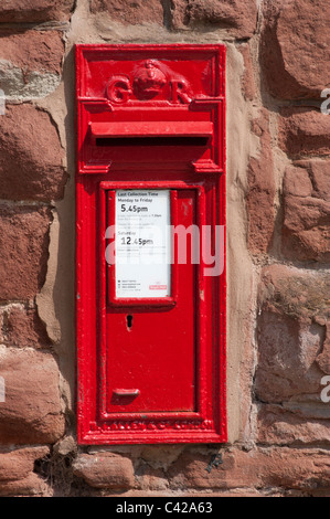 Red postbox in a stone wall, Chester, England. Stock Photo