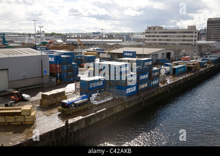 Aberdeen Scotland Piles of timber and shipping containers line the dock side of the harbour of this busy UK port Stock Photo
