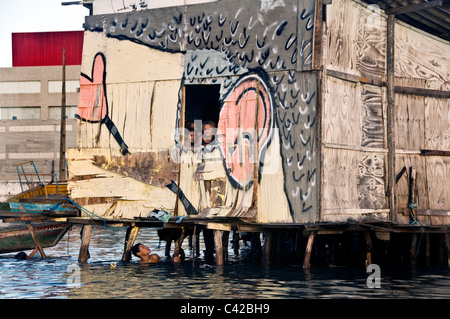 Palafitas or Stilt dwellers living and fishing on the river that flows through Recife in Northeastern Brazil. Stock Photo