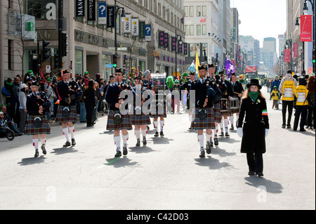 Traditional pipe band marching on Ste Catherine street in Montreal during the St Patrick's Day parade. Stock Photo