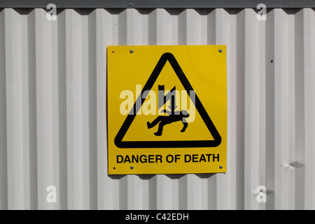 Sign. Health and Safety, 'DANGER of DEATH', on a perimeter fence to a Building Site. Stock Photo