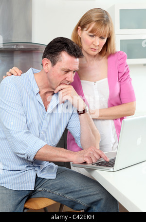 Worried couple looking at a laptop Stock Photo