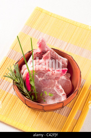 Raw pork chops in a terracotta bowl Stock Photo