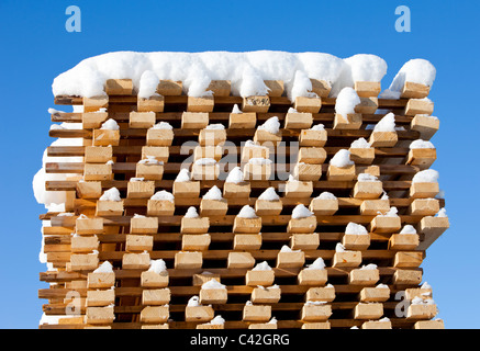 Snow on top of pile of 2 by 4 planks , Finland Stock Photo