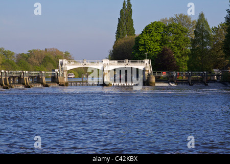 The weir at Teddington on the Thames showing the tidal waters and fish pass for salmon, with trees in the background Stock Photo