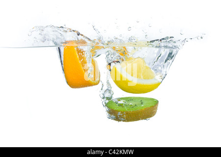 sliced citrus fruit with kiwi splashing isolated on white background Stock Photo