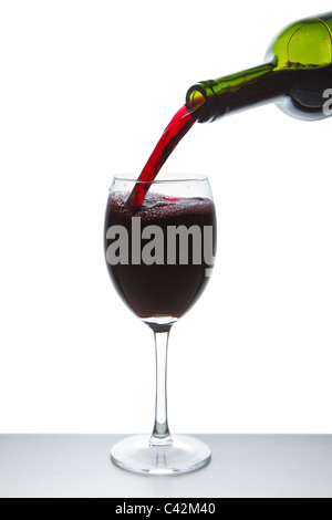 red wine pouring into wine glass isolated Stock Photo