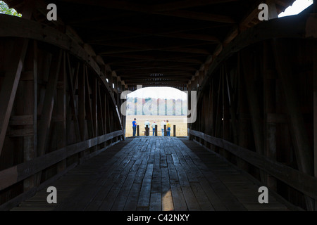 People standing at one end of Neet Covered Bridge, built in 1904 spanning the Little Raccoon Creek in Parke County, Indiana, USA Stock Photo
