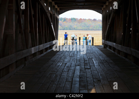 People standing at one end of Neet Covered Bridge, built in 1904 spanning the Little Raccoon Creek in Parke County, Indiana, USA Stock Photo