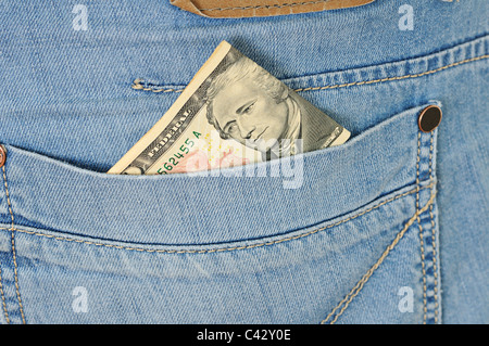 Ten dollars stick out of a pocket of blue jeans Stock Photo