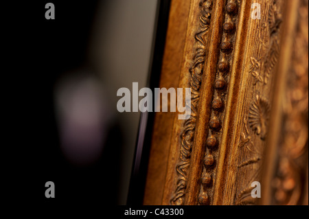Detail picture of intricate woodwork on the frame of a mirror. Stock Photo