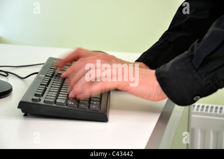 Man typing on keyboard close-up blurred motion Stock Photo