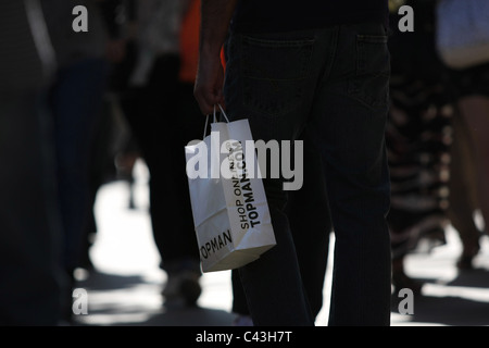 A Topman carrier bag being carried in a crowd of people Stock Photo