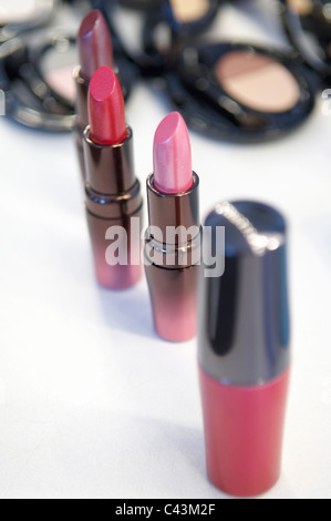Still life of designer lipsticks on white table Stock Photo