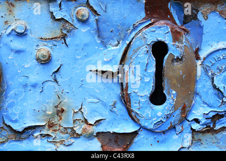 Layers of weathered and peeling blue paint on an old door lock Stock Photo