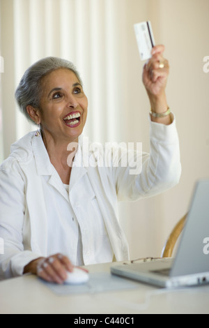 African American woman shopping online with credit card and laptop computer Stock Photo