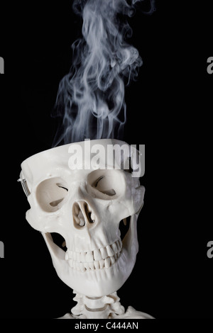 A skeleton with smoke coming out of its skull Stock Photo